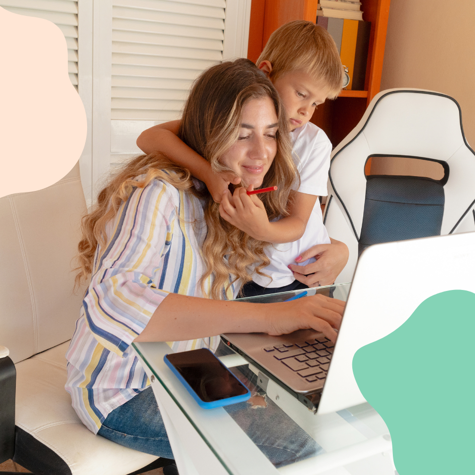 Mother sitting at a computer with her child beside her, both focused on the screen